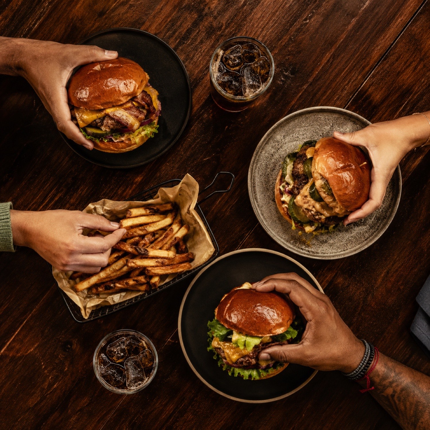 Tisch von oben mit mehreren Burgern und Getränken